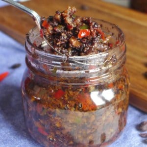 scooping out spicy black bean sauce from a jar