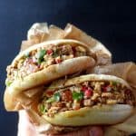 Two Chinese pork burgers held by a hand.
