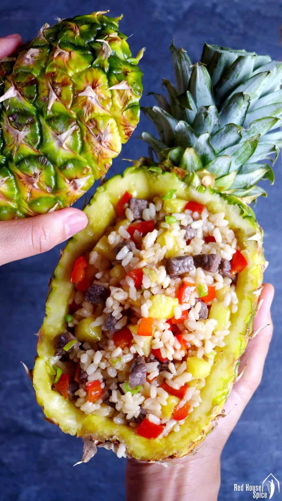 A hollowed pineapple with fried rice inside