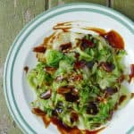 Iceberg lettuce topped with brown-coloured, thick sauce.