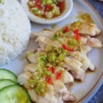 sliced chicken with scallion and chilli dressing with overlay text that says one-pot chicken rice
