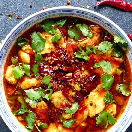 Sichuan boiled fish garnished with coriander and topped with dried chilli and Sichuan pepper.
