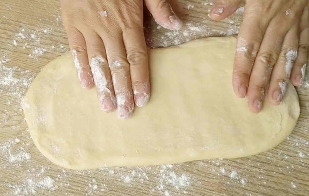 flatten a piece of dough by hands
