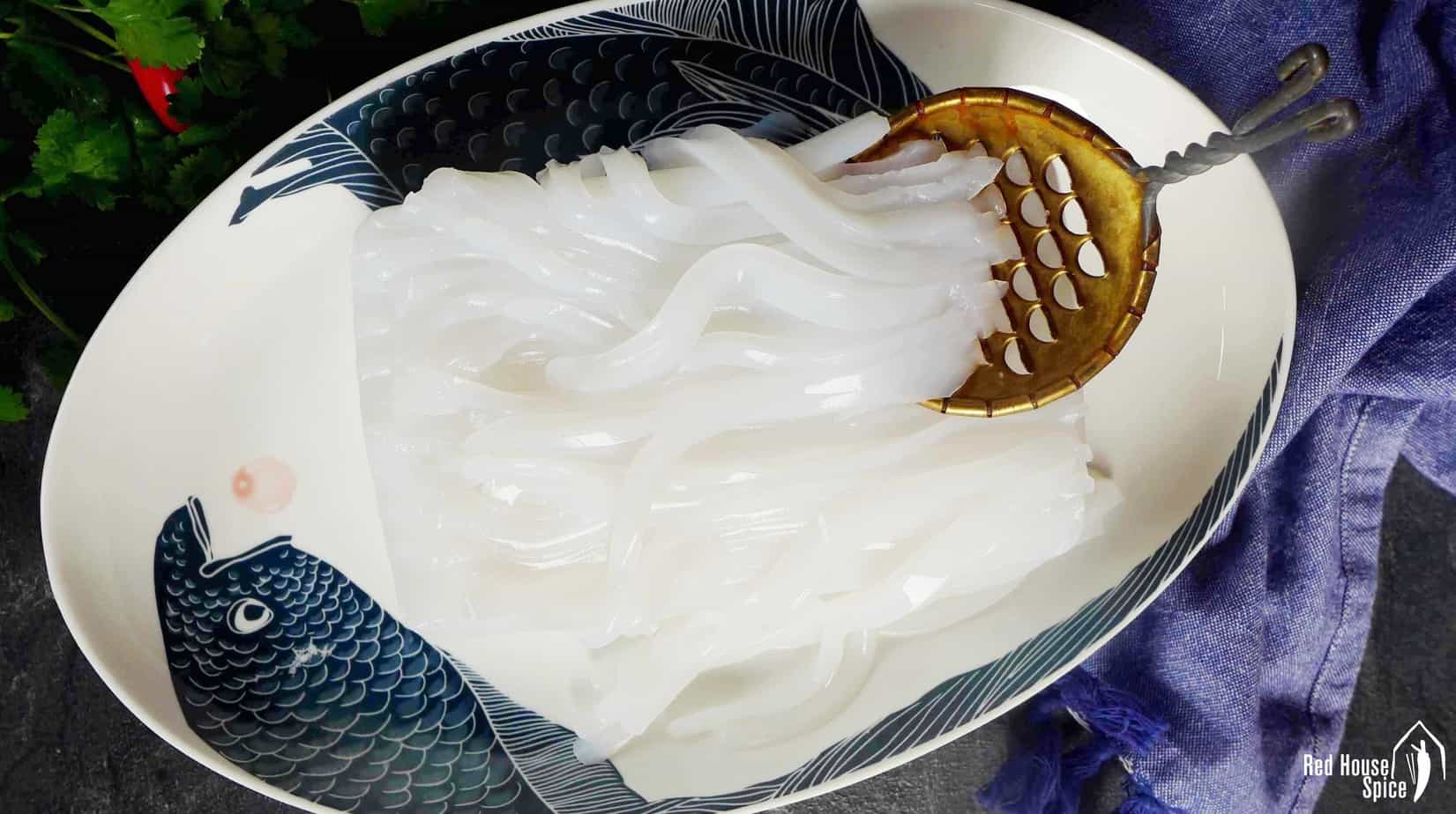 Use a special slicer to make noodle like stripes from a block of Mung bean jelly (Liangfen).