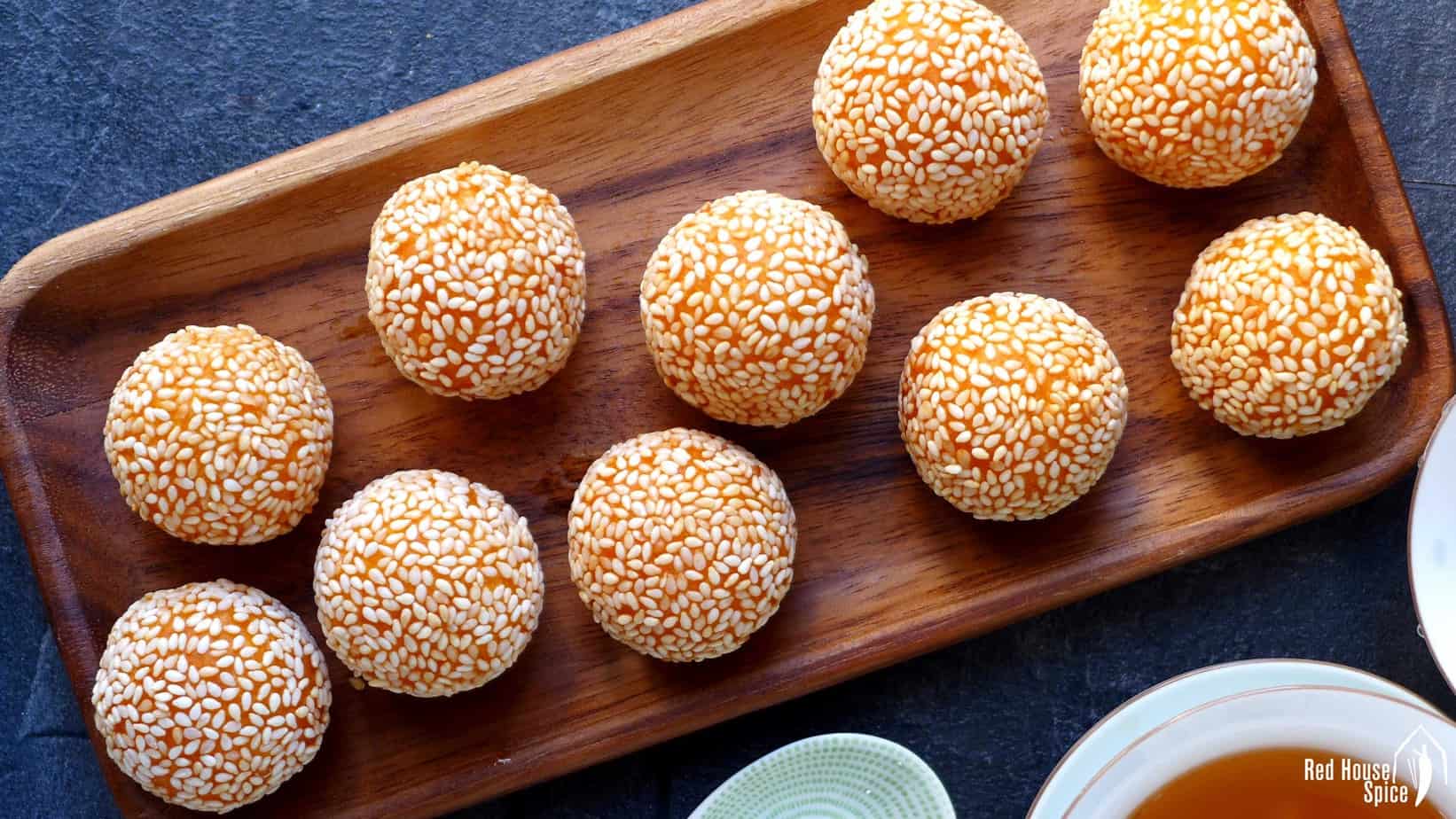 Delicious Chinese sesame balls on a wooden plate.