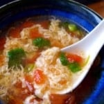 Spooning tomato egg drop soup.