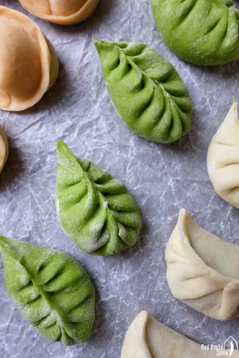 Chinese dumplings made in green colour and leaf pattern.