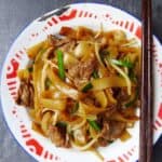 a plate of stir fried rice noodles with beef