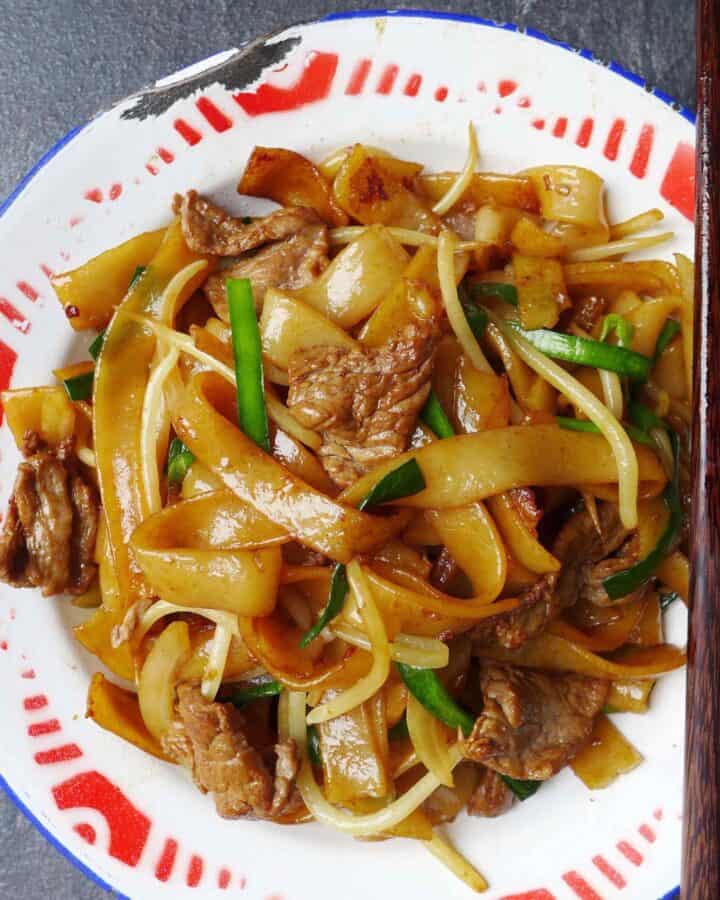 a plate of stir fried rice noodles with beef