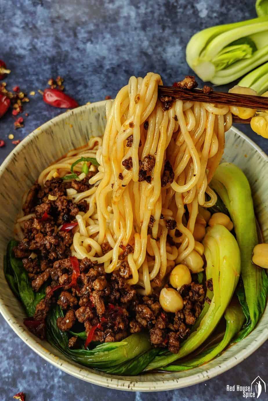 Chongqing noodles lifted up by a pair of chopsticks.