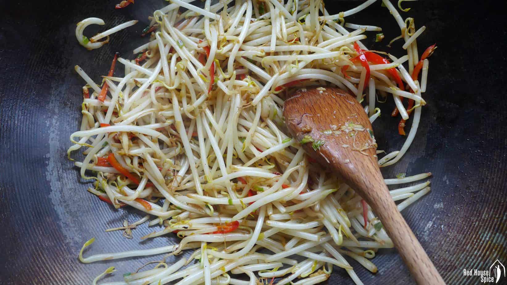 Stir-frying mung bean sprouts in a wok