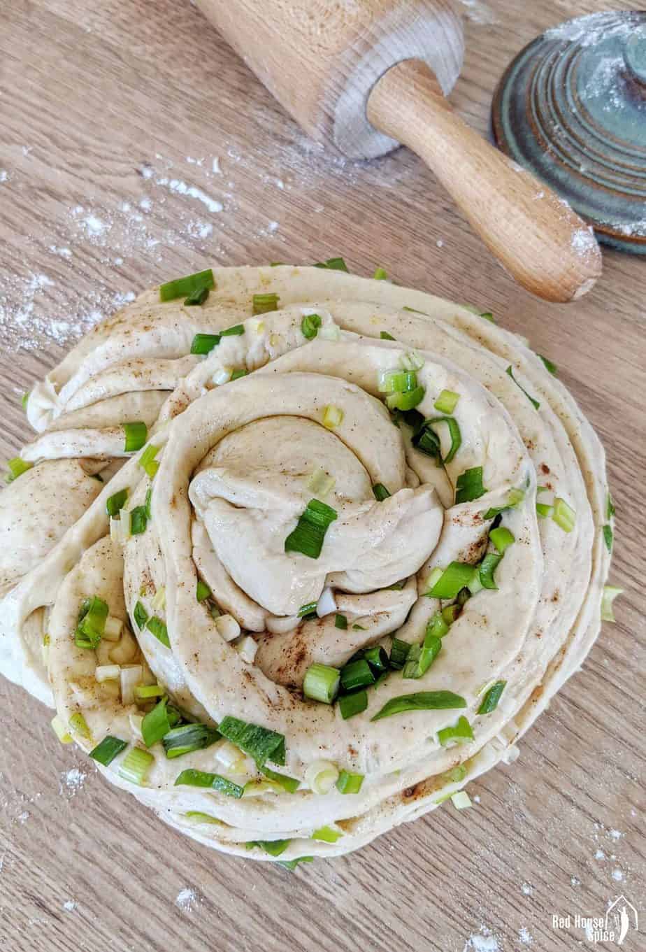 A piece of bread dough garnished with scallions
