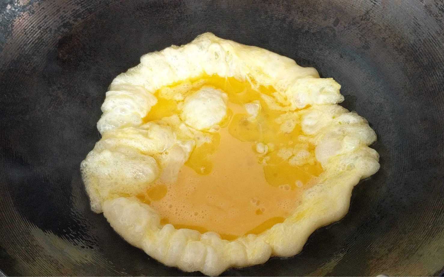 Making scrambled egg in a wok