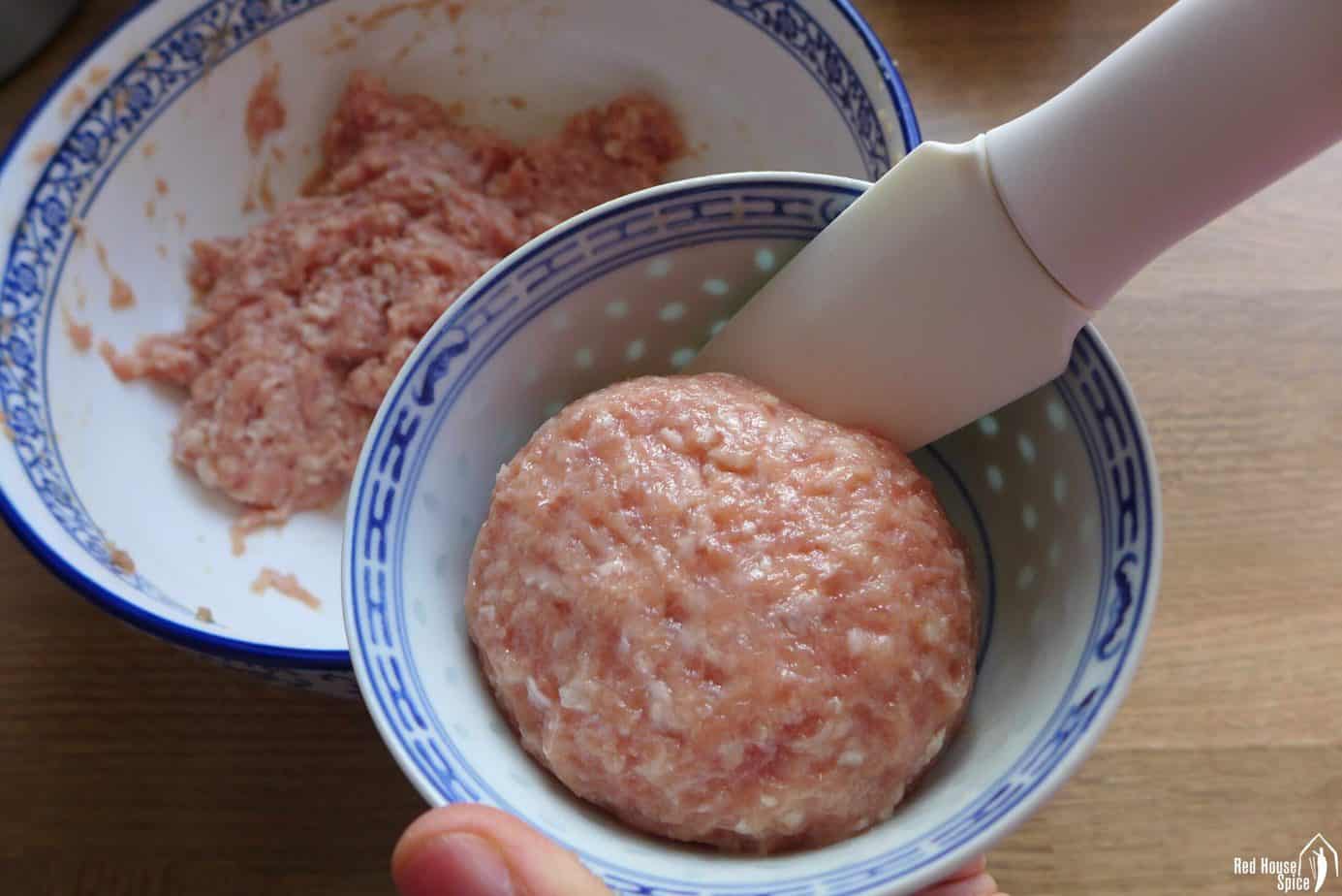 Shaping a meatball in a small bowl