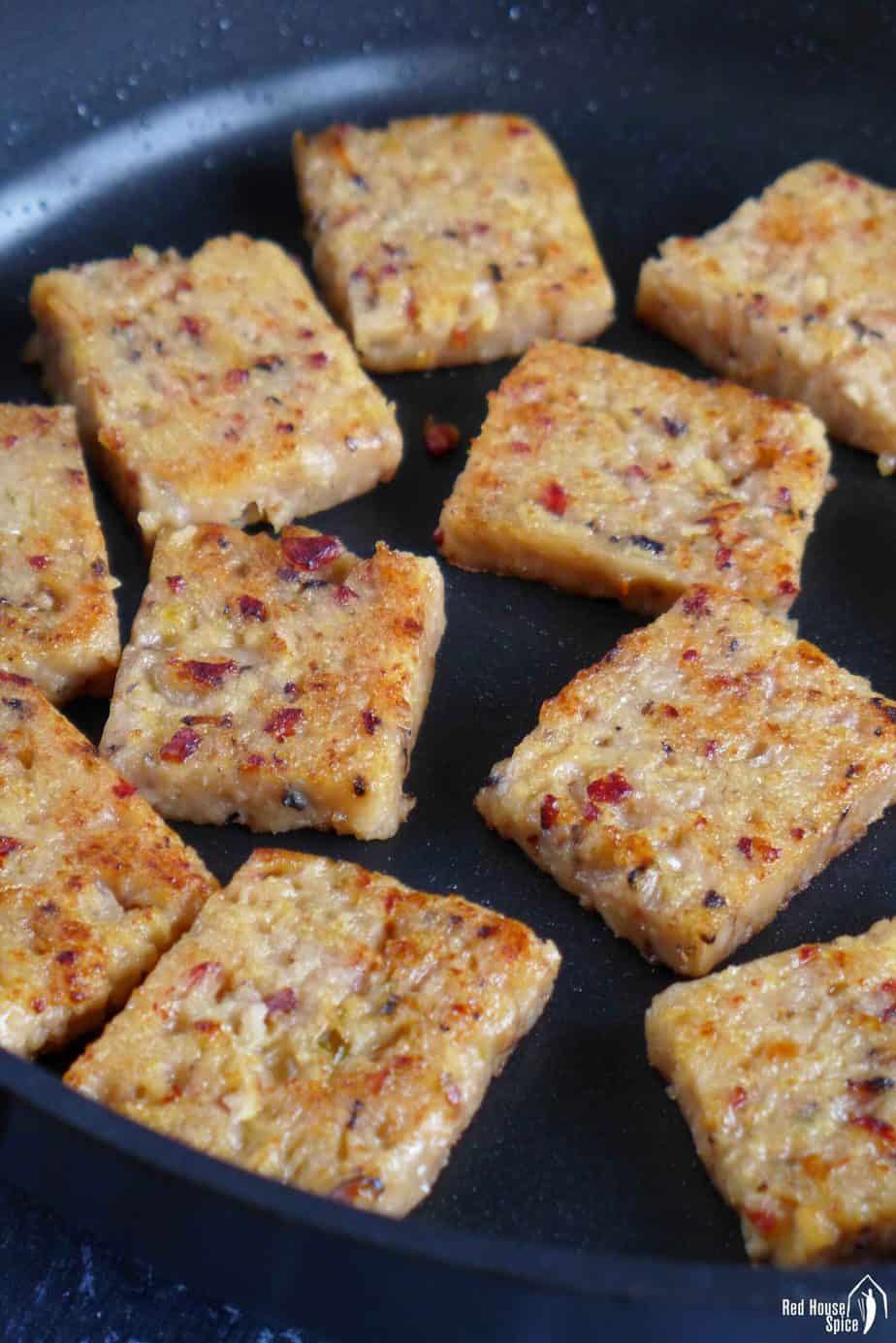 Frying turnip cake slices in a pan