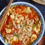Noodles with tomato and egg soup in a bowl with overlay text that says tomato egg noodle soup