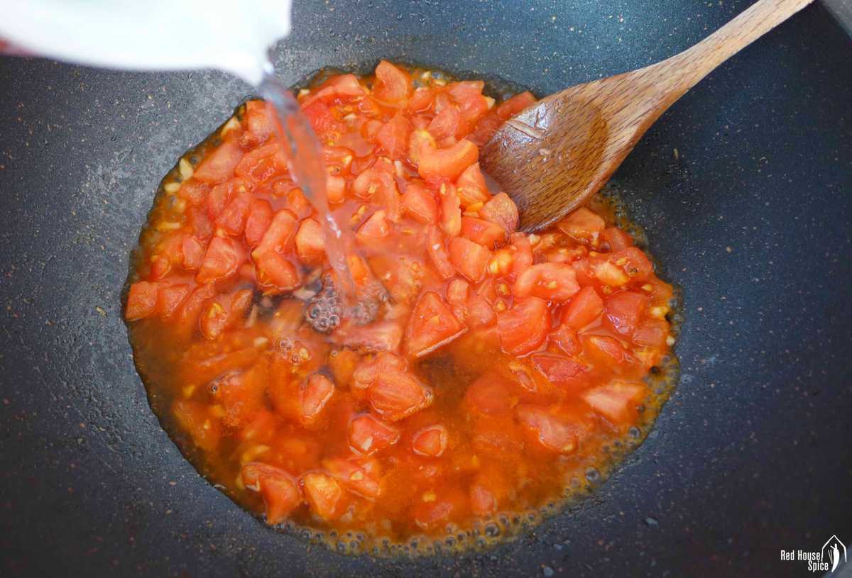 Pouring water over chopped tomatoes