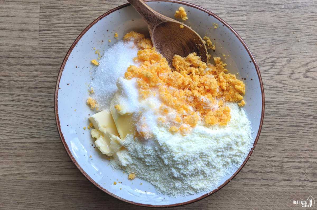 mashed yolks, sugar, butter and milk powder in a bowl