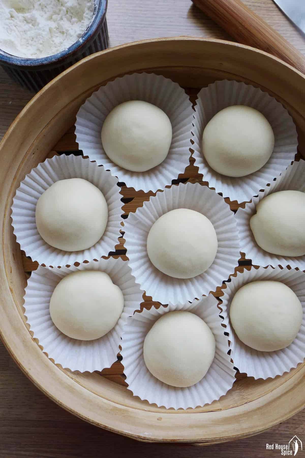 uncooked buns in a steamer