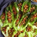 Lettuce wraps with pork fillings on a tray with overlay text that says Sichuan lettuce wrap