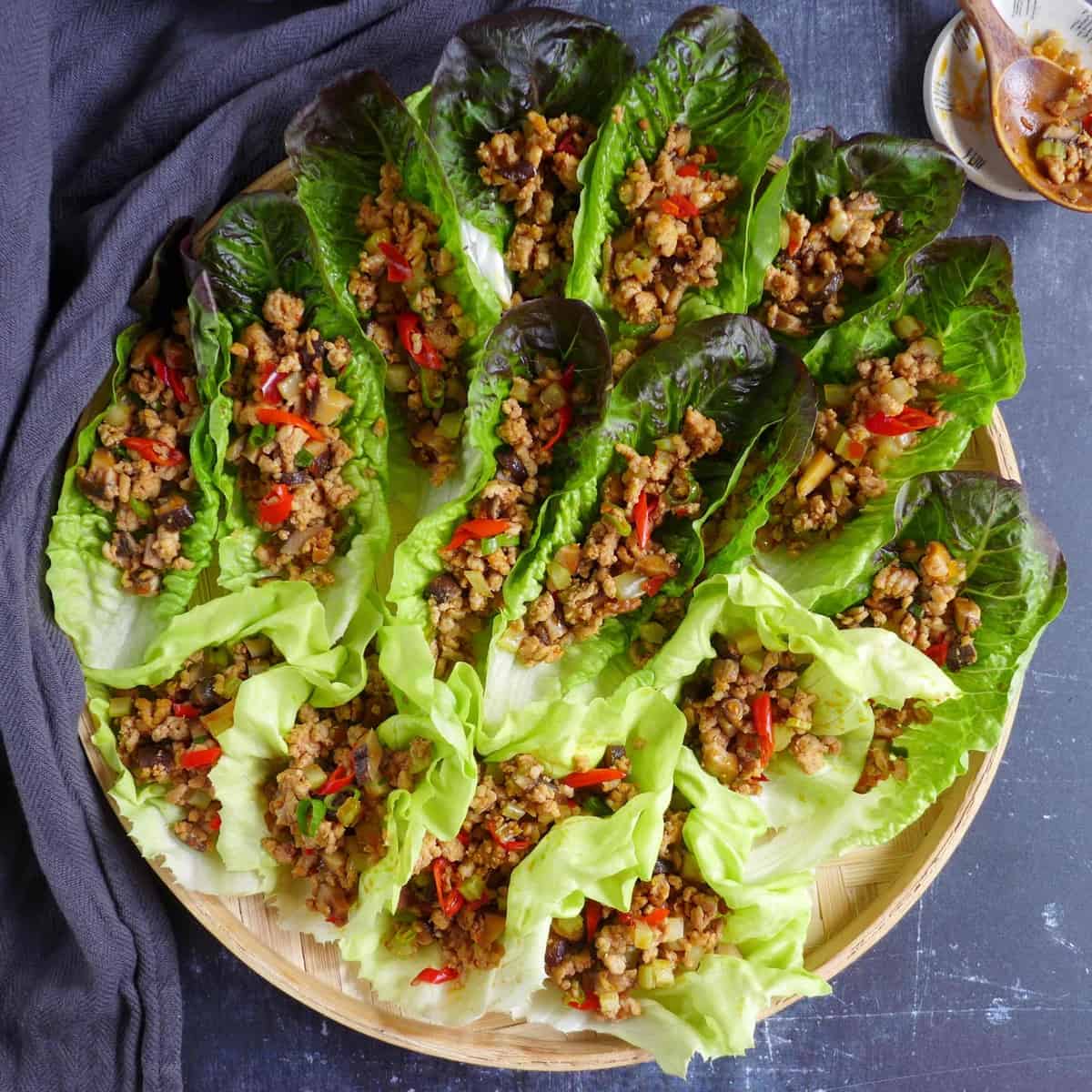 A tray of lettuce wraps with pork filling