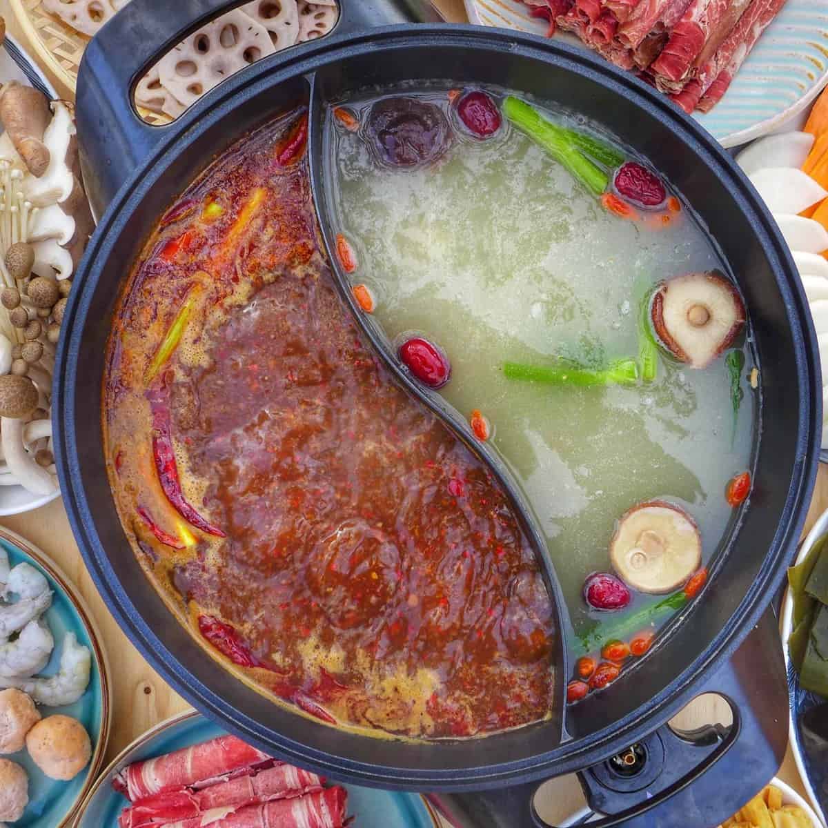 a divided pot filled with spicy and mild broth