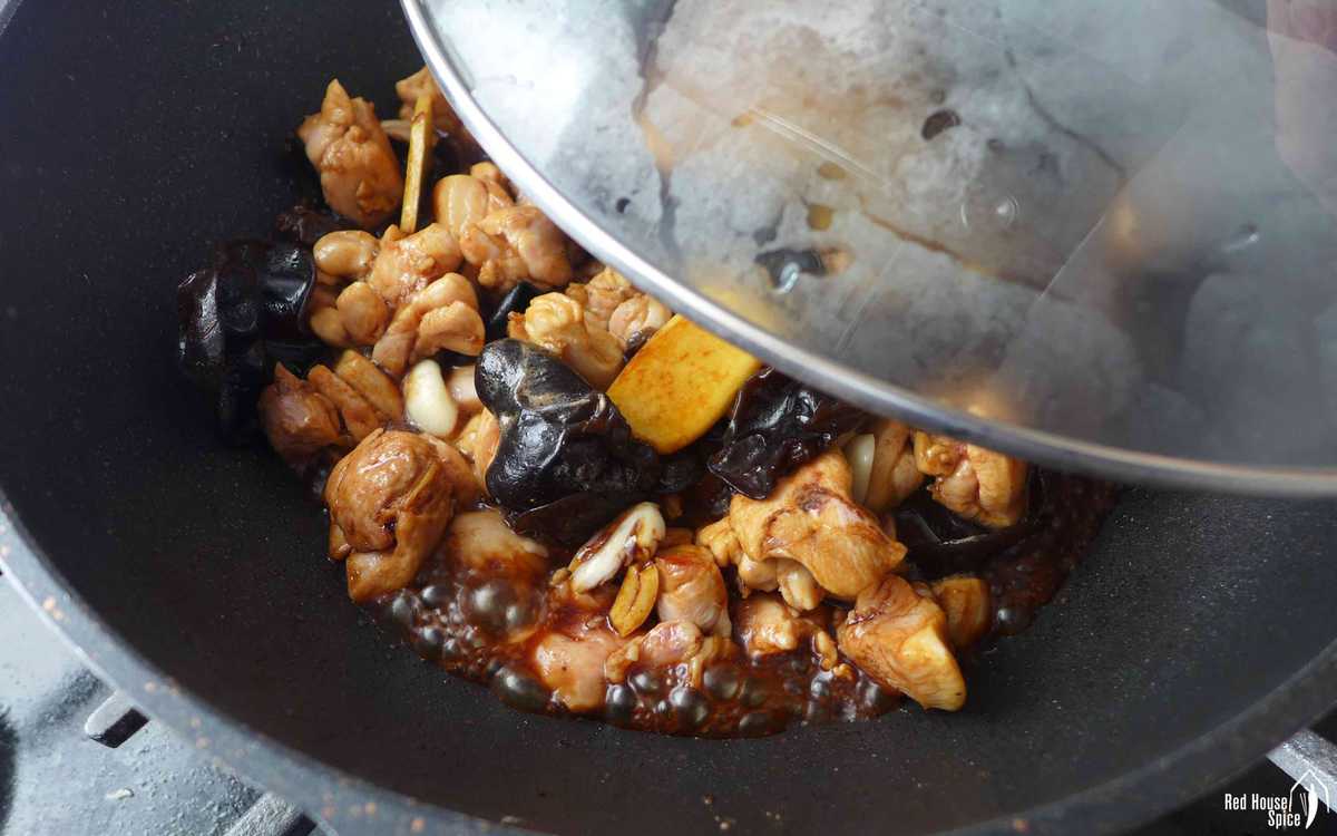putting lid over a wok with chicken inside