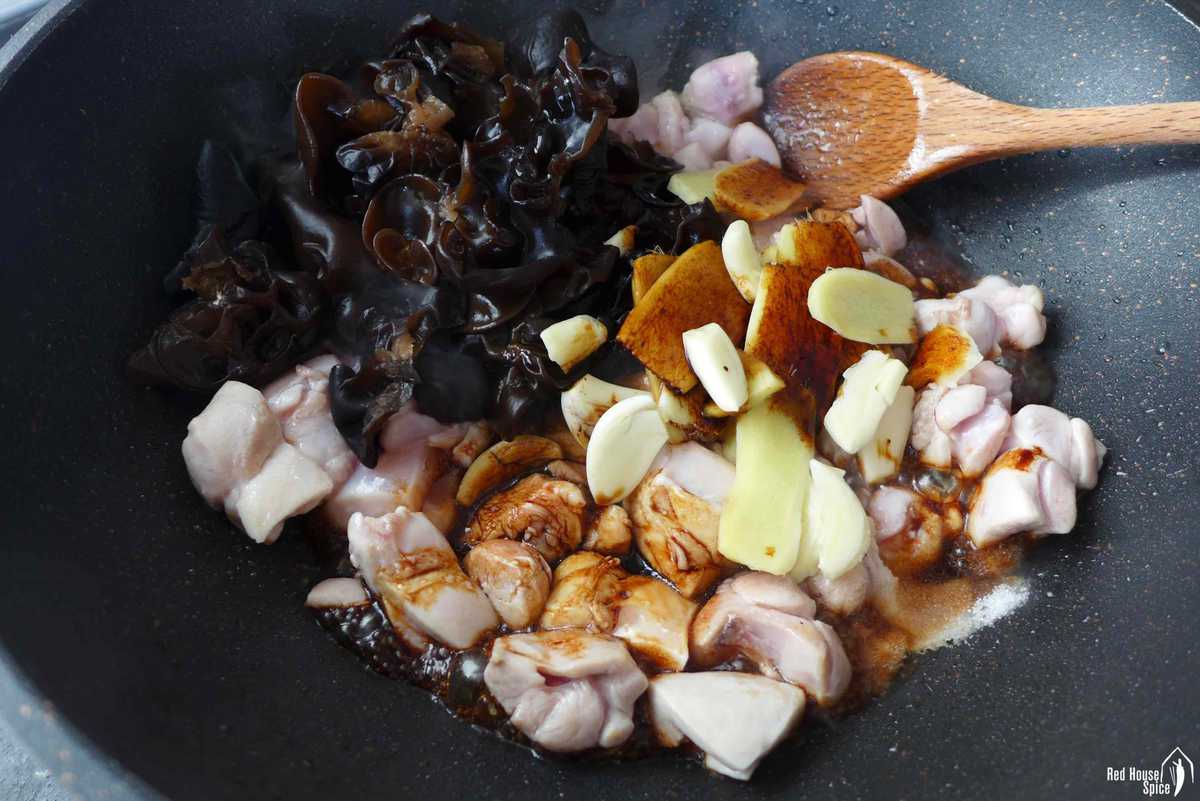 chicken, ginger, wood ear and soy sauce in a wok