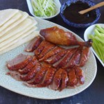 Sliced Peking duck with thin pancakes, dark sauce, and julienned vegetables