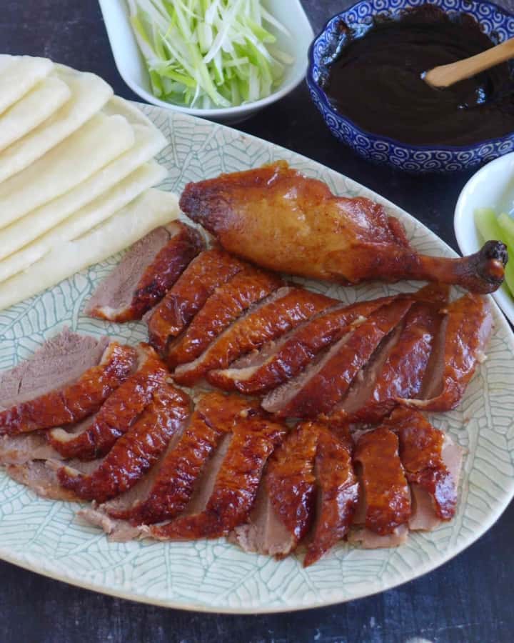 Sliced Peking duck with thin pancakes, dark sauce, and julienned vegetables