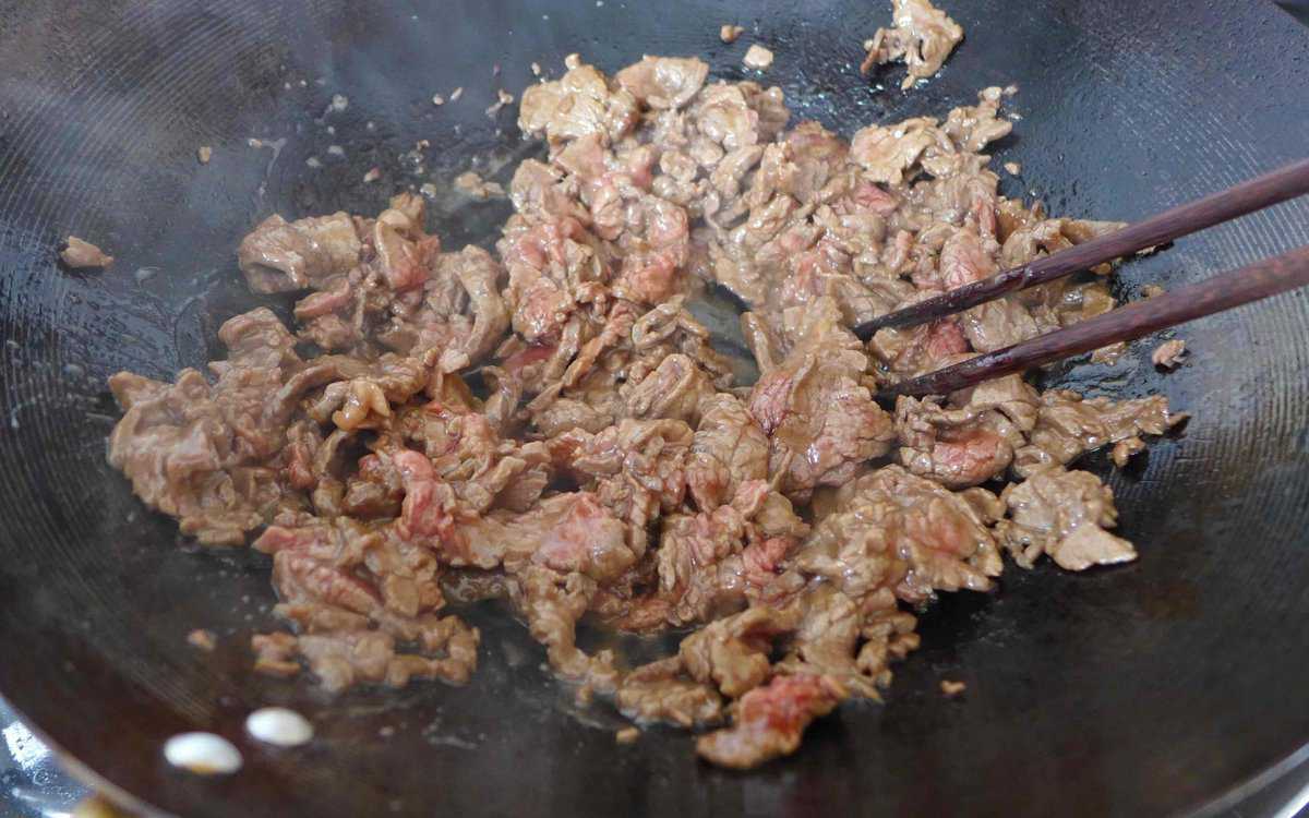 searing beef slices in a wok