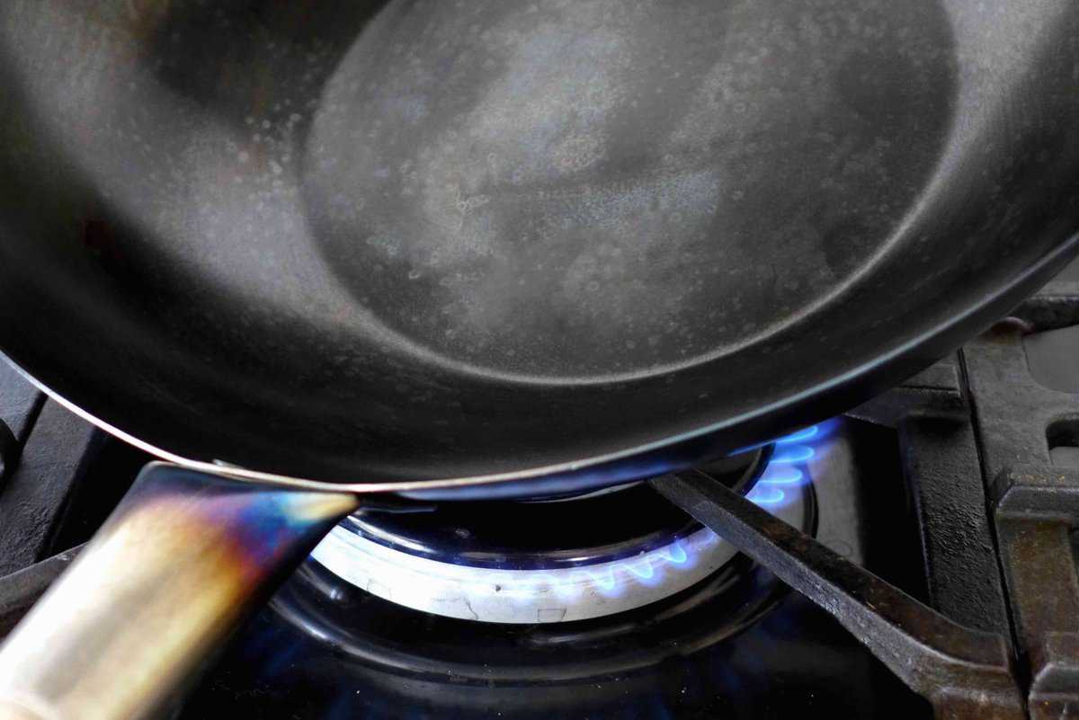 heating a wok over flame