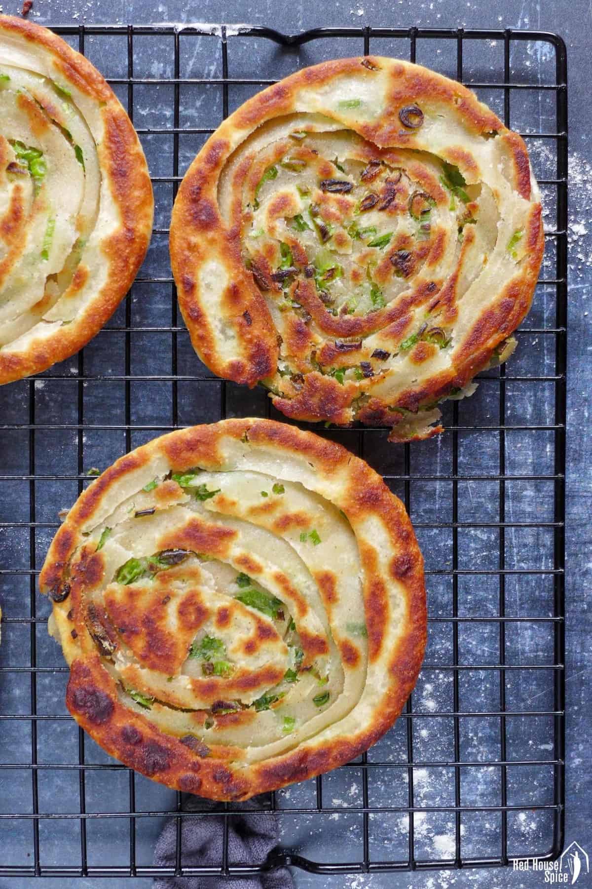 two scallion pancakes on a wire rack