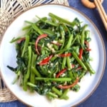 a plate of stir-fried water spinach with chilli, garlic and fermented tofu