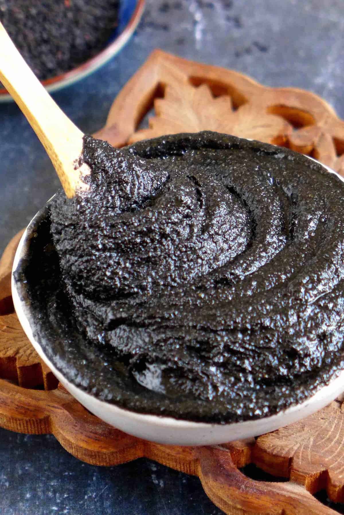 A bowl of black sesame paste with a spoon.