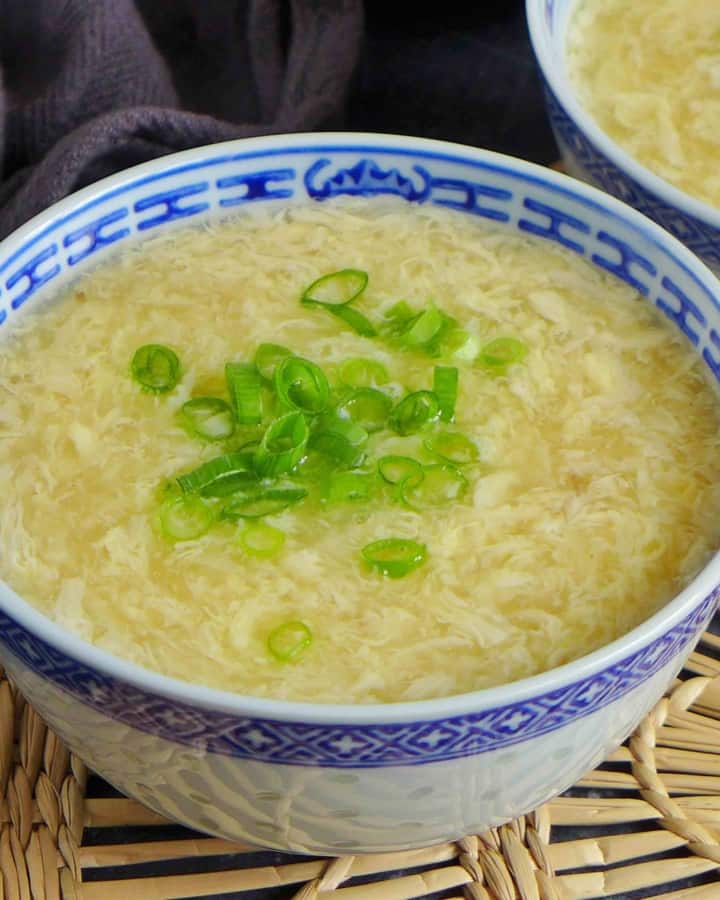 A bowl of egg drop soup with scallions.