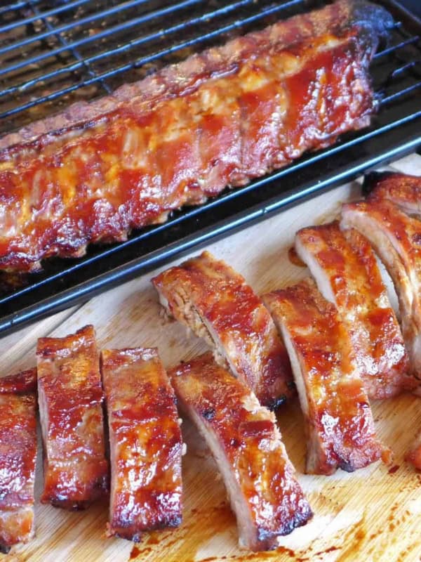 BBQ ribs on a chopping board and on a tray.