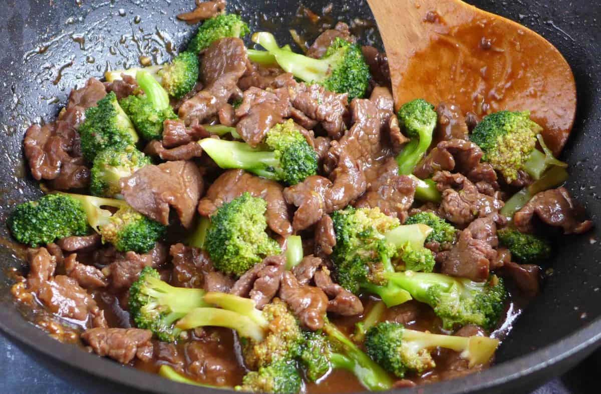 beef and Broccoli covered with sauce in a wok.