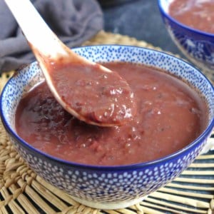 A bowl of sweet red bean soup with a spoon.