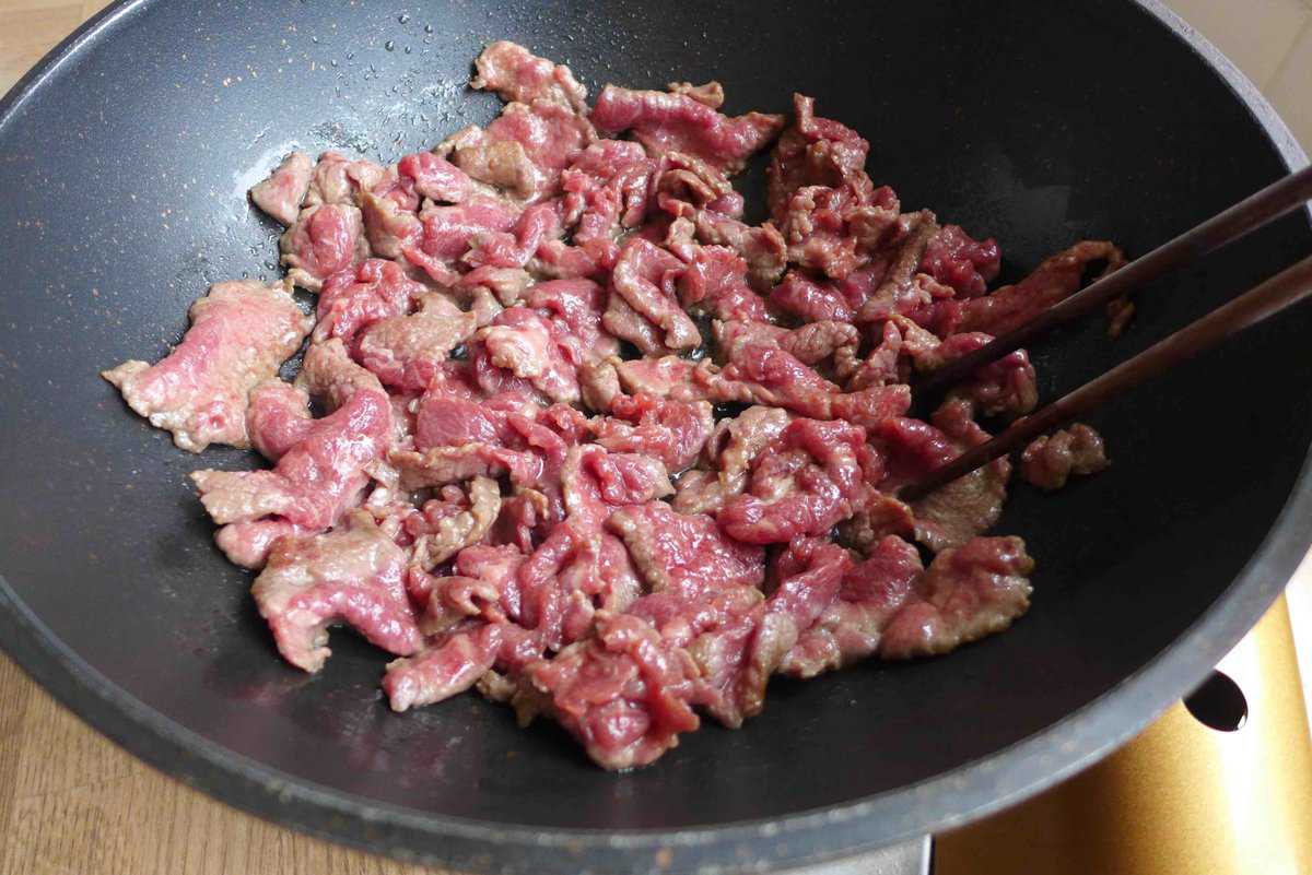 searing beef slices in a wok.