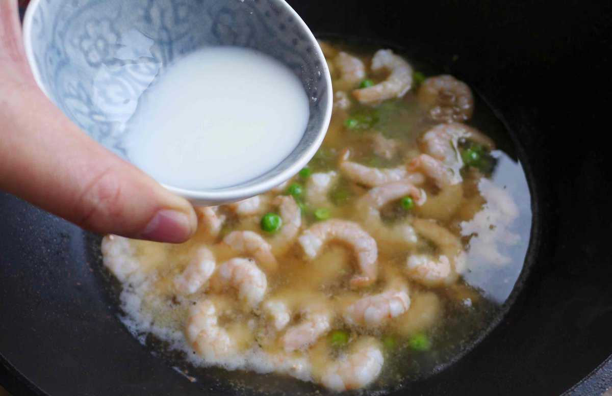 pouring cornstarch slurry to shrimp in broth.
