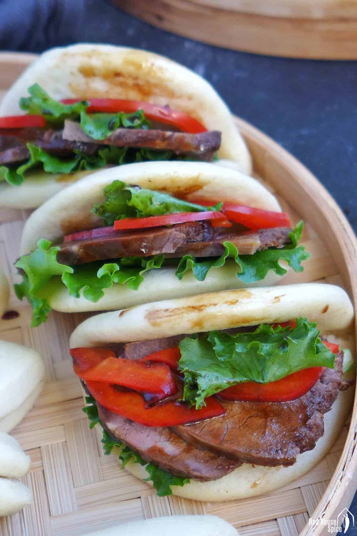 folded bao buns with beef and vegetable filling.