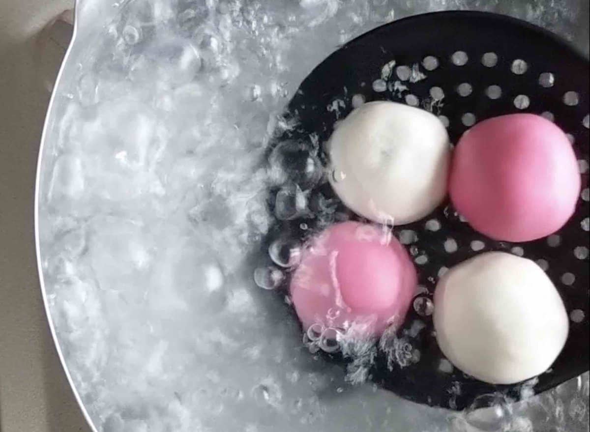 Putting uncooked Tang Yuan into boiling water.