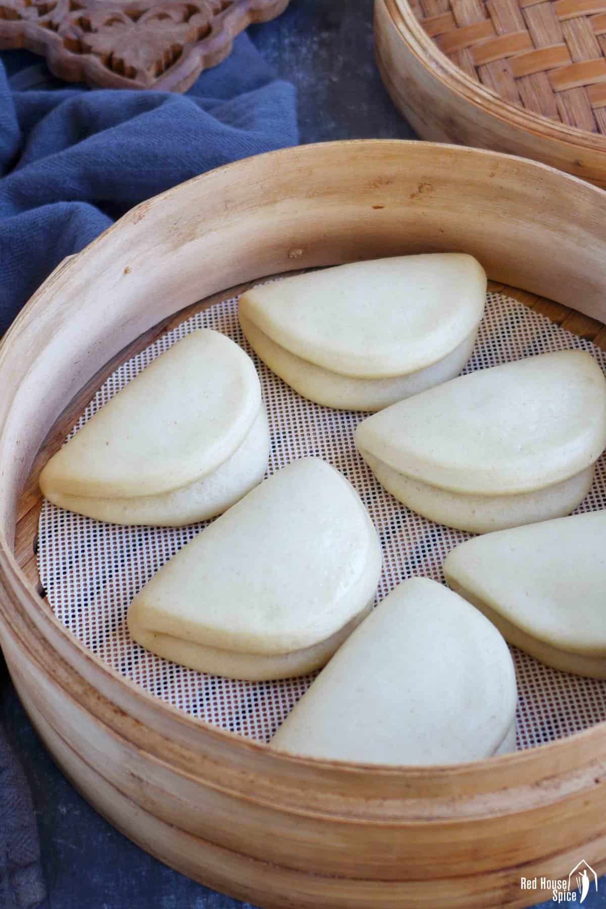 cooked plain bao buns in a steamer.
