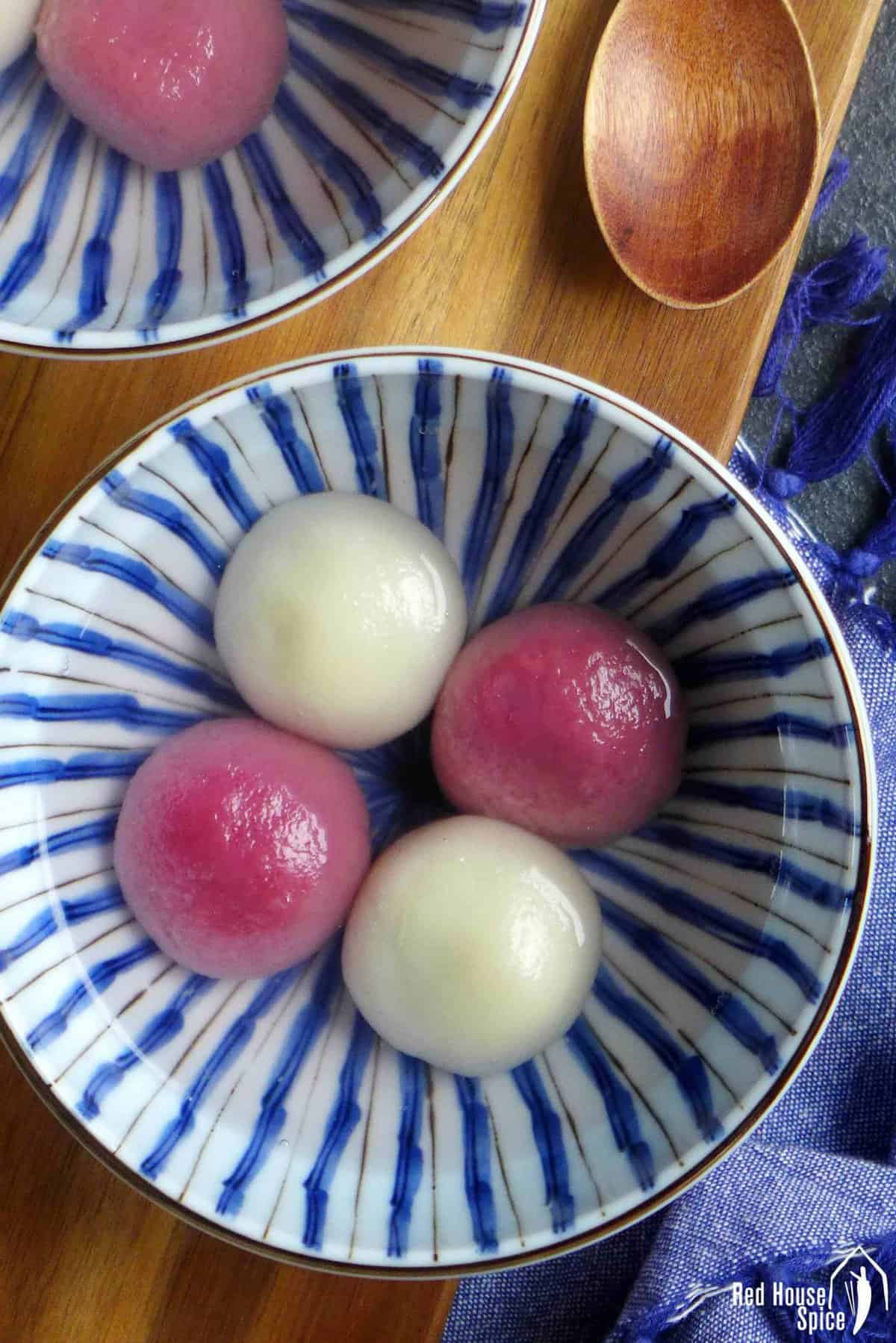 two white and two pink tang yuan in a bowl.