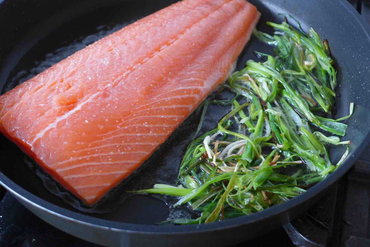 pan-frying salmon side with scallions and ginger.