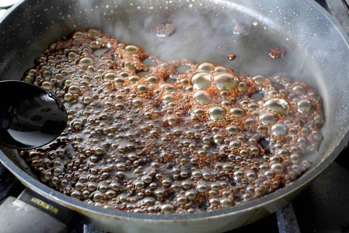 dark sauce bubbling in a pan.
