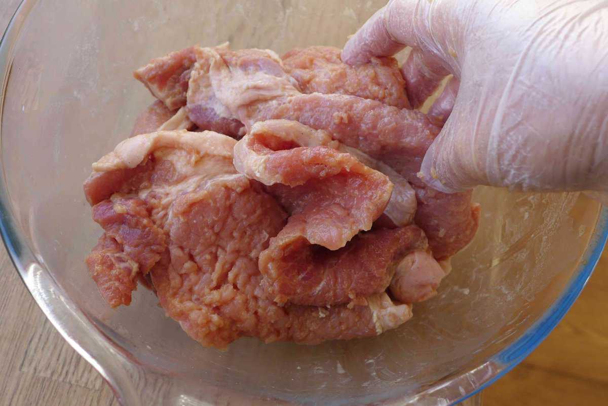 rubbing marinade into pork chops.