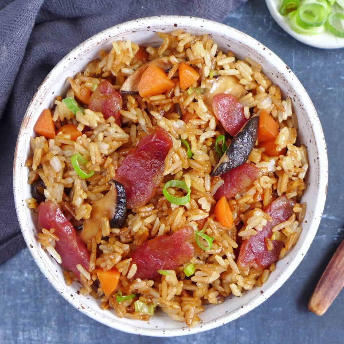 Chinese sausage rice with carrots and mushroom in a bowl.