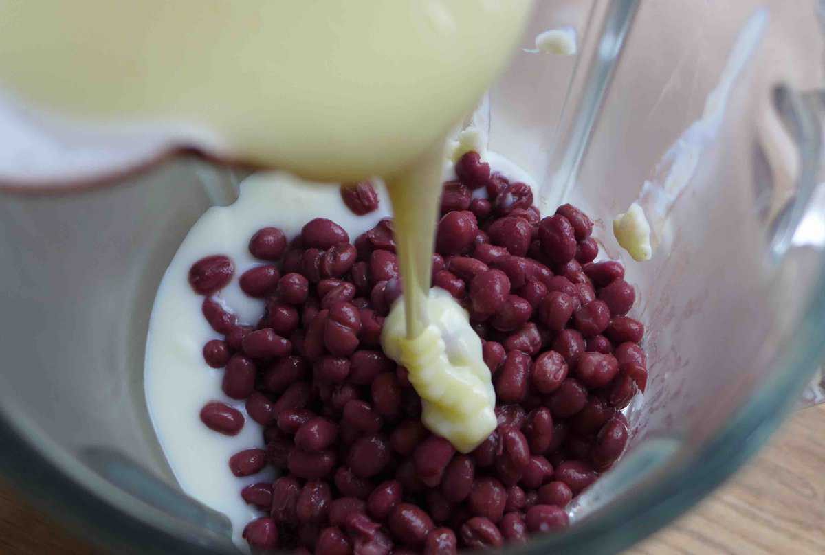 pouring condensed milk over cooked red beans.